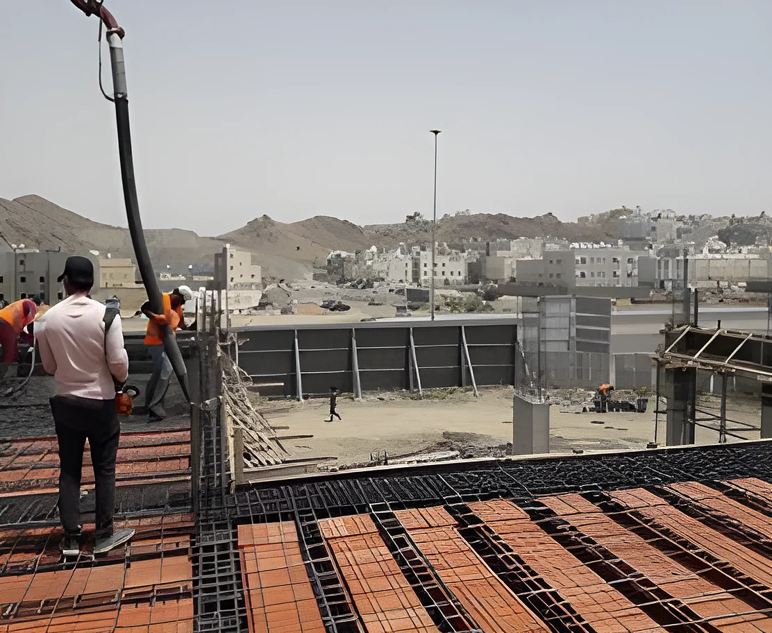 Concrete pour over a reinforced slab, with Taif's hills behind